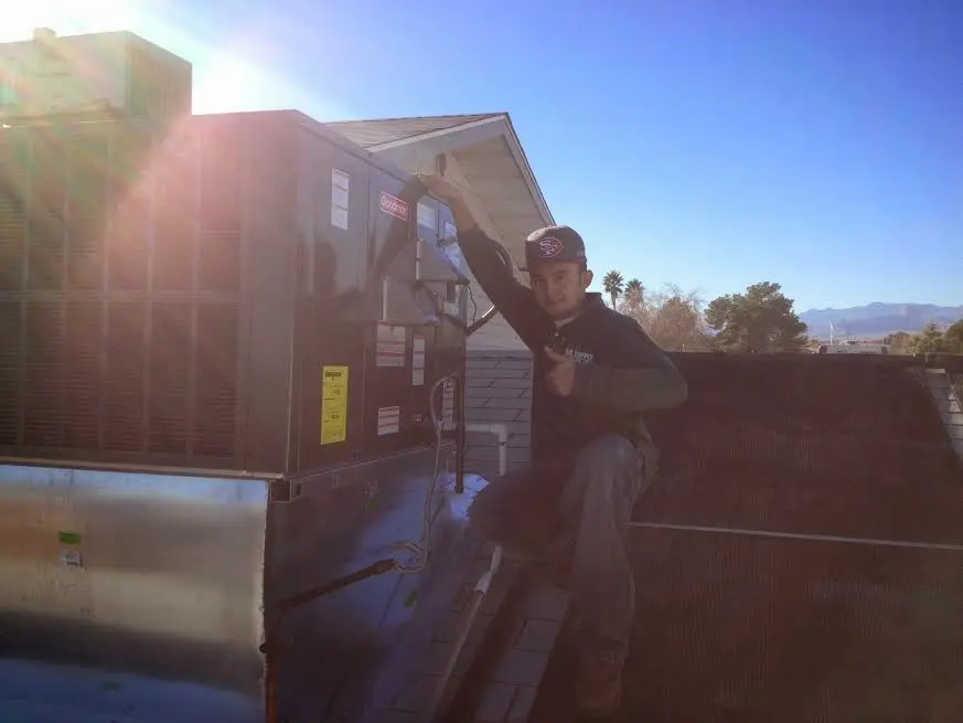 HVAC technician performing Heat Pump Repair on a rooftop unit in Woodstock
